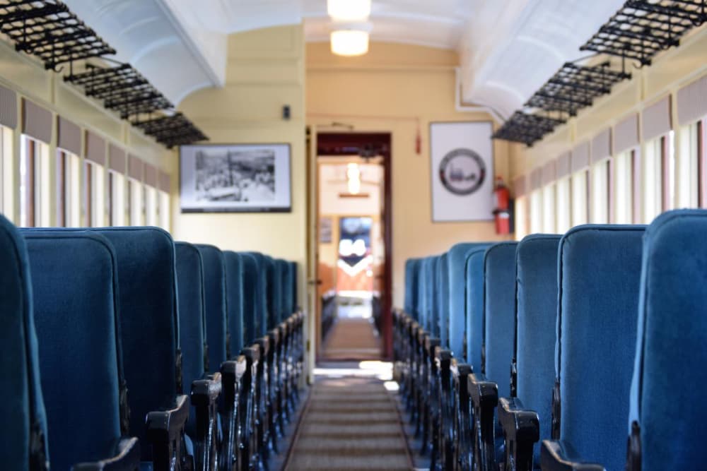 Rows of blue cloth seats inside a vintage train.