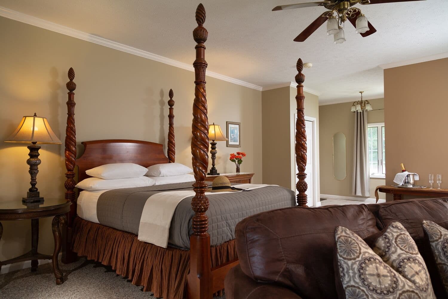 A cozy bedroom featuring a four-poster bed, soft lighting, and decorative furnishings.