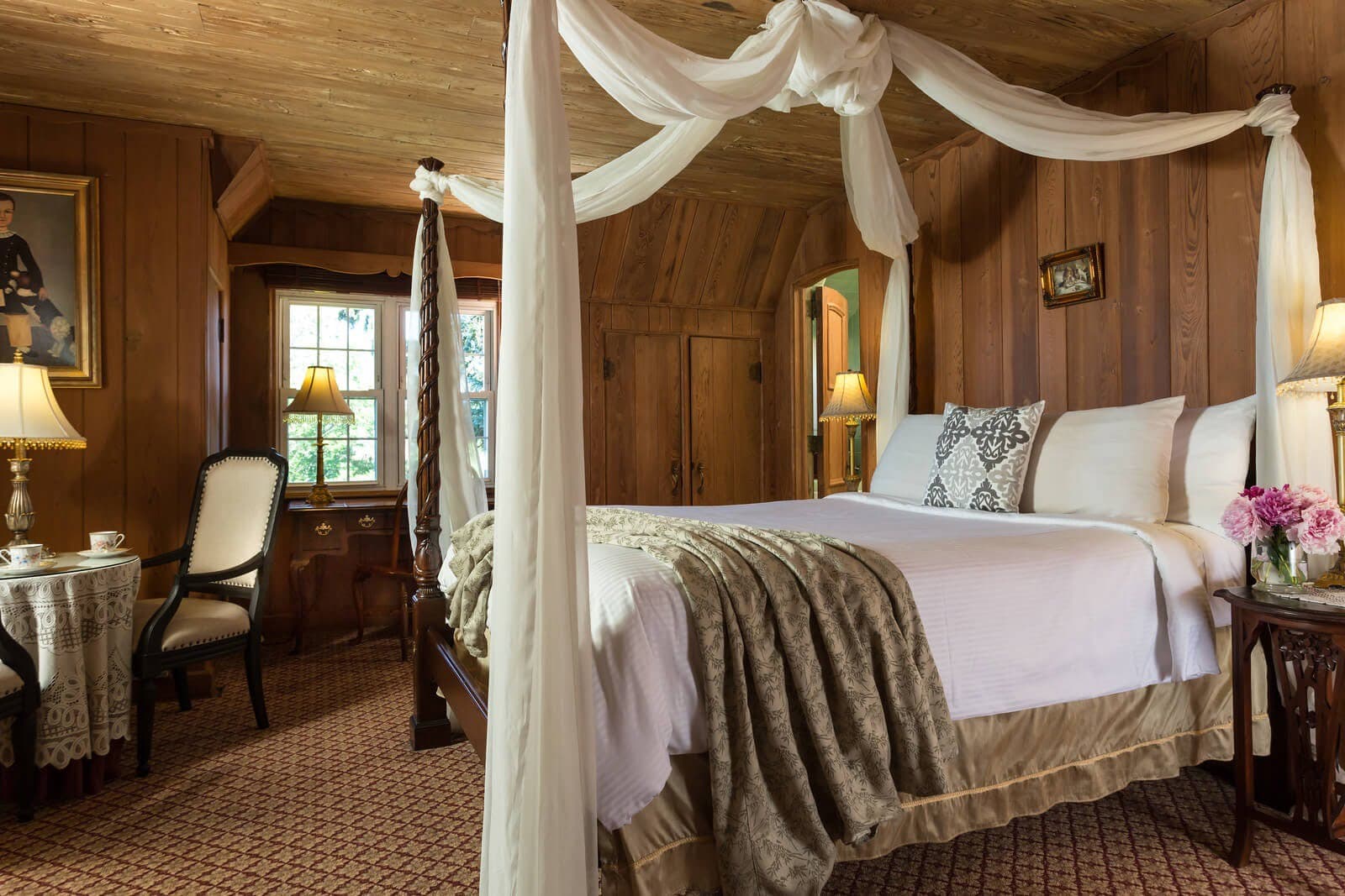 Cozy bedroom with wooden walls, a canopy bed, and elegant furnishings.