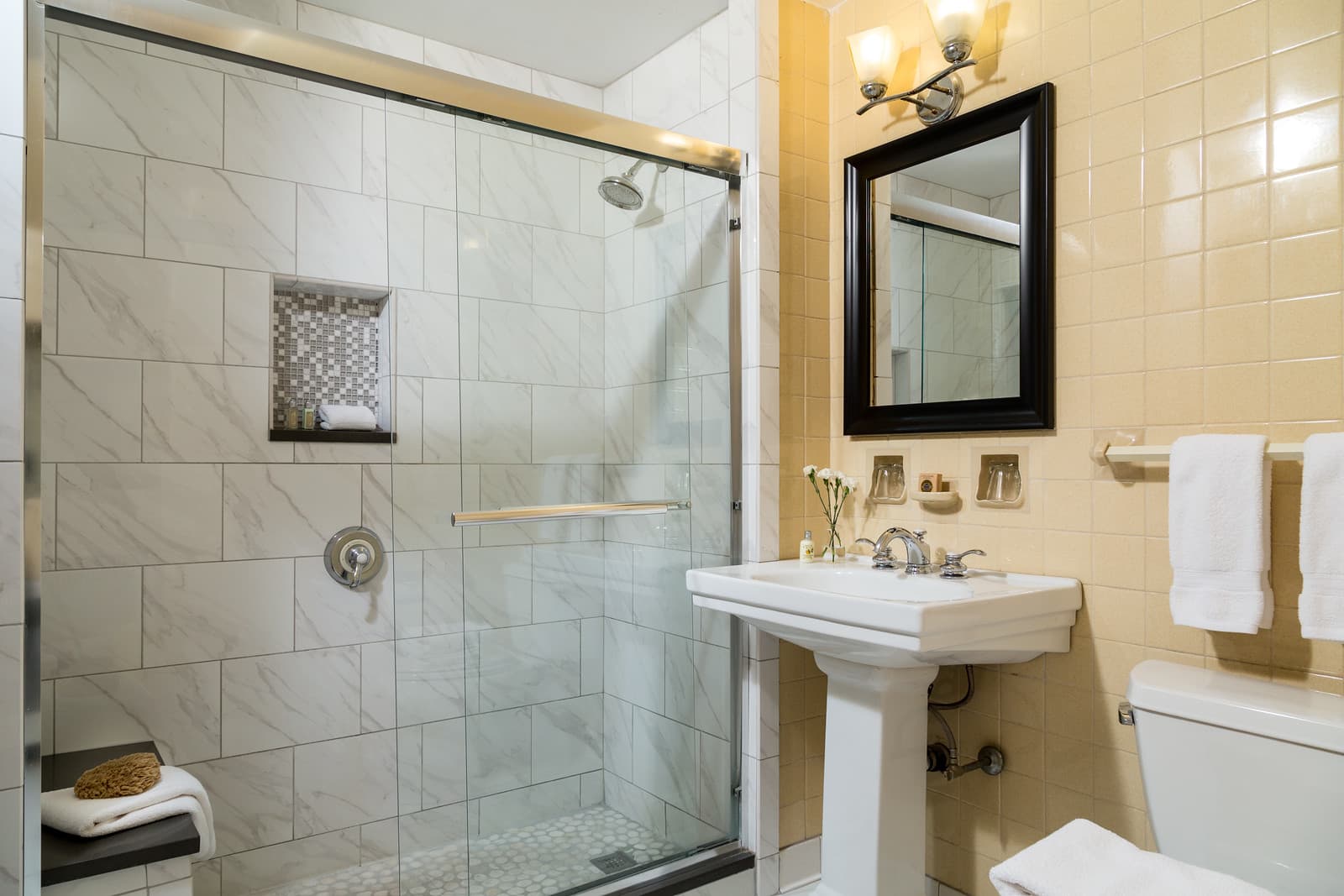 Modern bathroom featuring a glass shower, white sink, and a mirror on the wall.