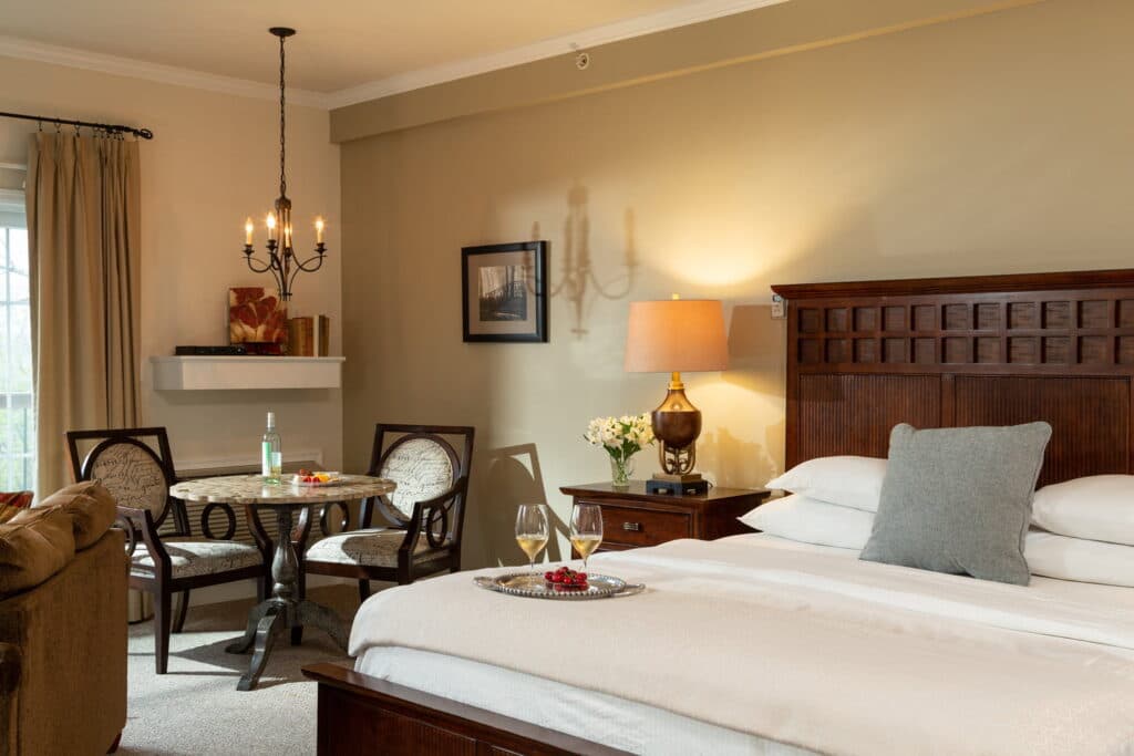 A cozy hotel room featuring a bed, dining table, and soft lighting.