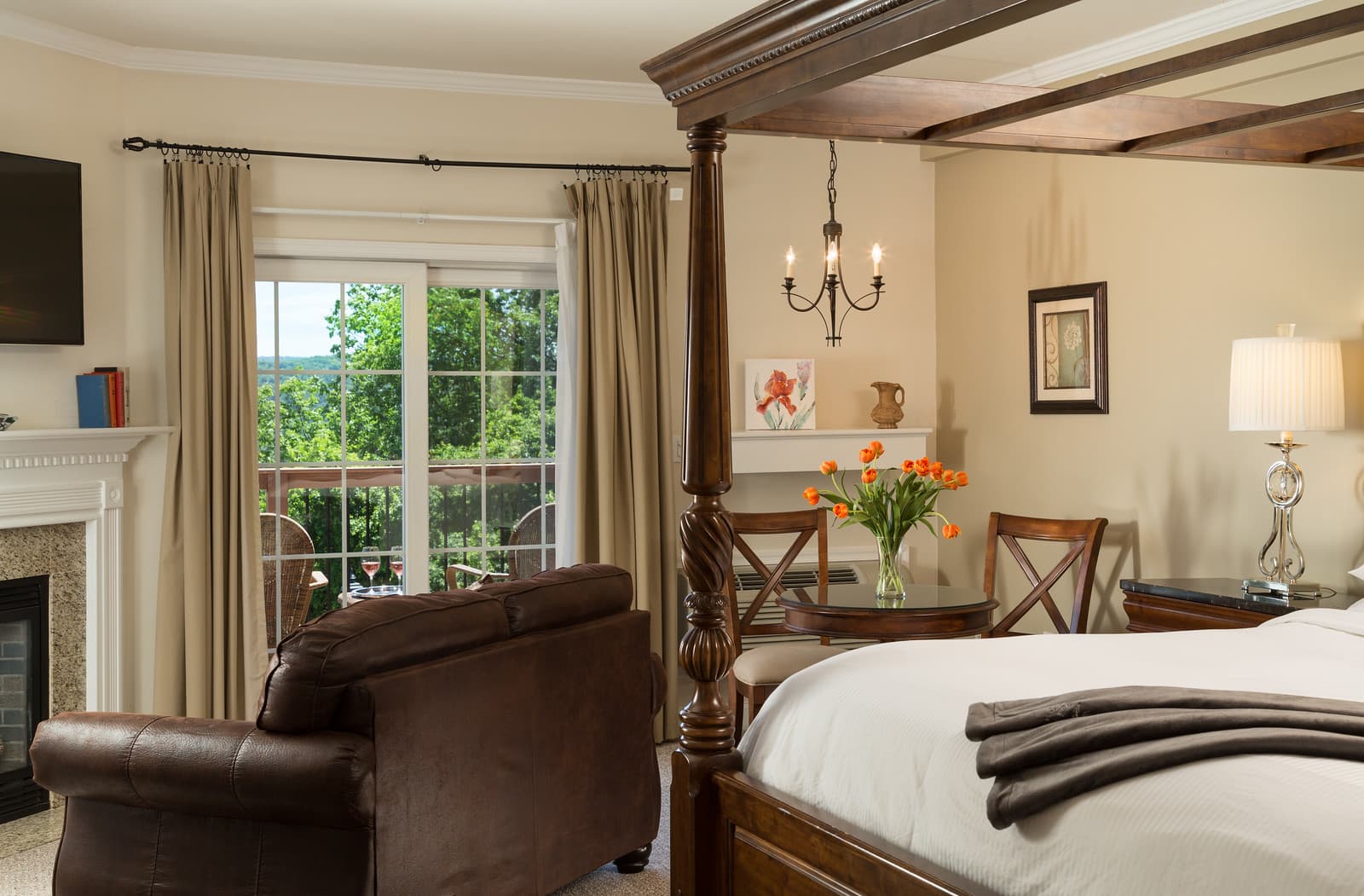 Cozy bedroom featuring a four-poster bed, seating area, and large windows with a view.