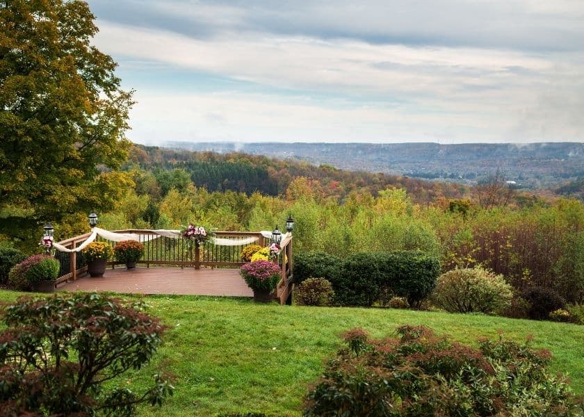 A scenic view of a wooden deck overlooking a colorful autumn landscape.