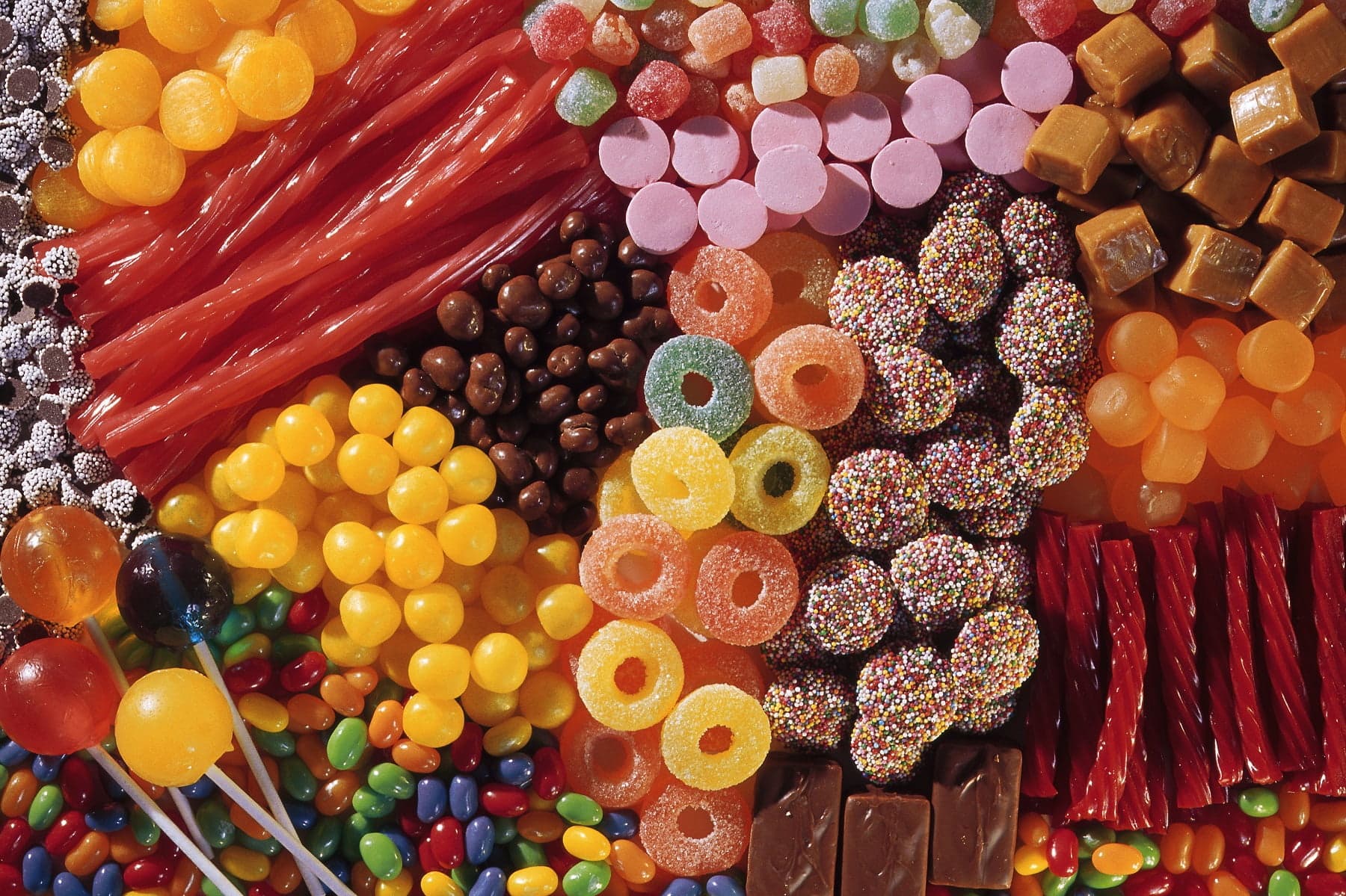 A colorful assortment of various candies, including gummies, chocolates, lollipops, and licorice.