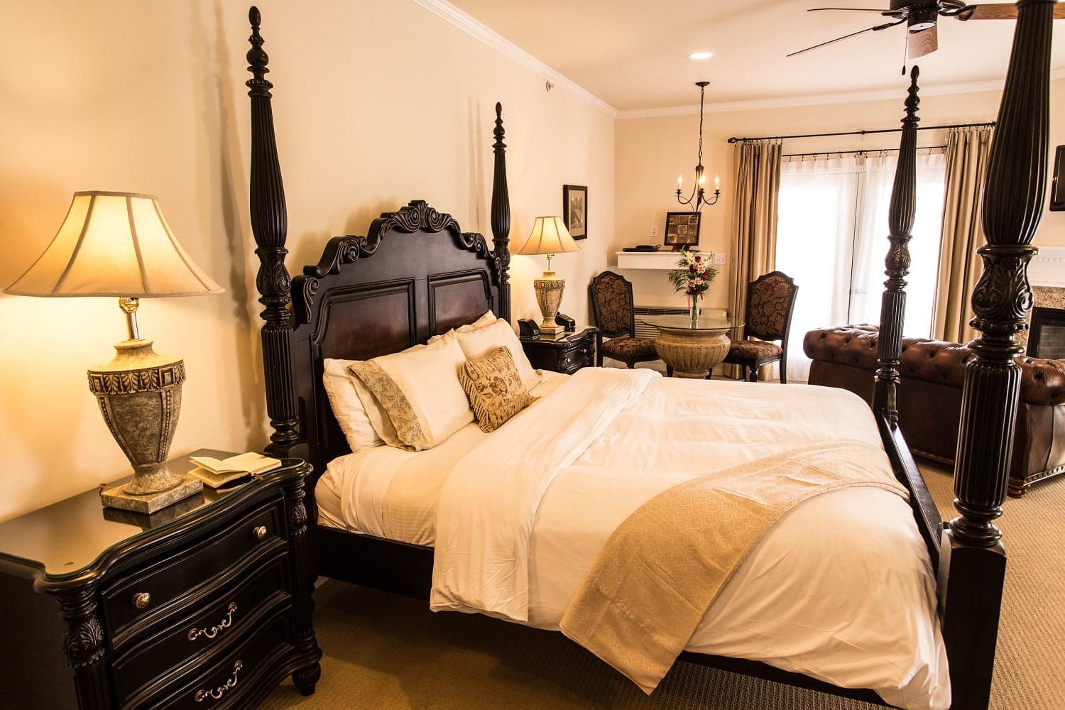 A luxurious bedroom featuring a four-poster bed, elegant furnishings, and soft lighting.